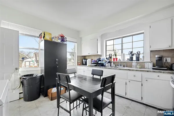 a kitchen with a refrigerator a stove a sink dishwasher and white cabinets with wooden floor
