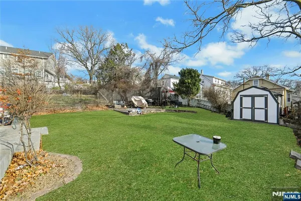 a view of a chair and table in backyard of the house
