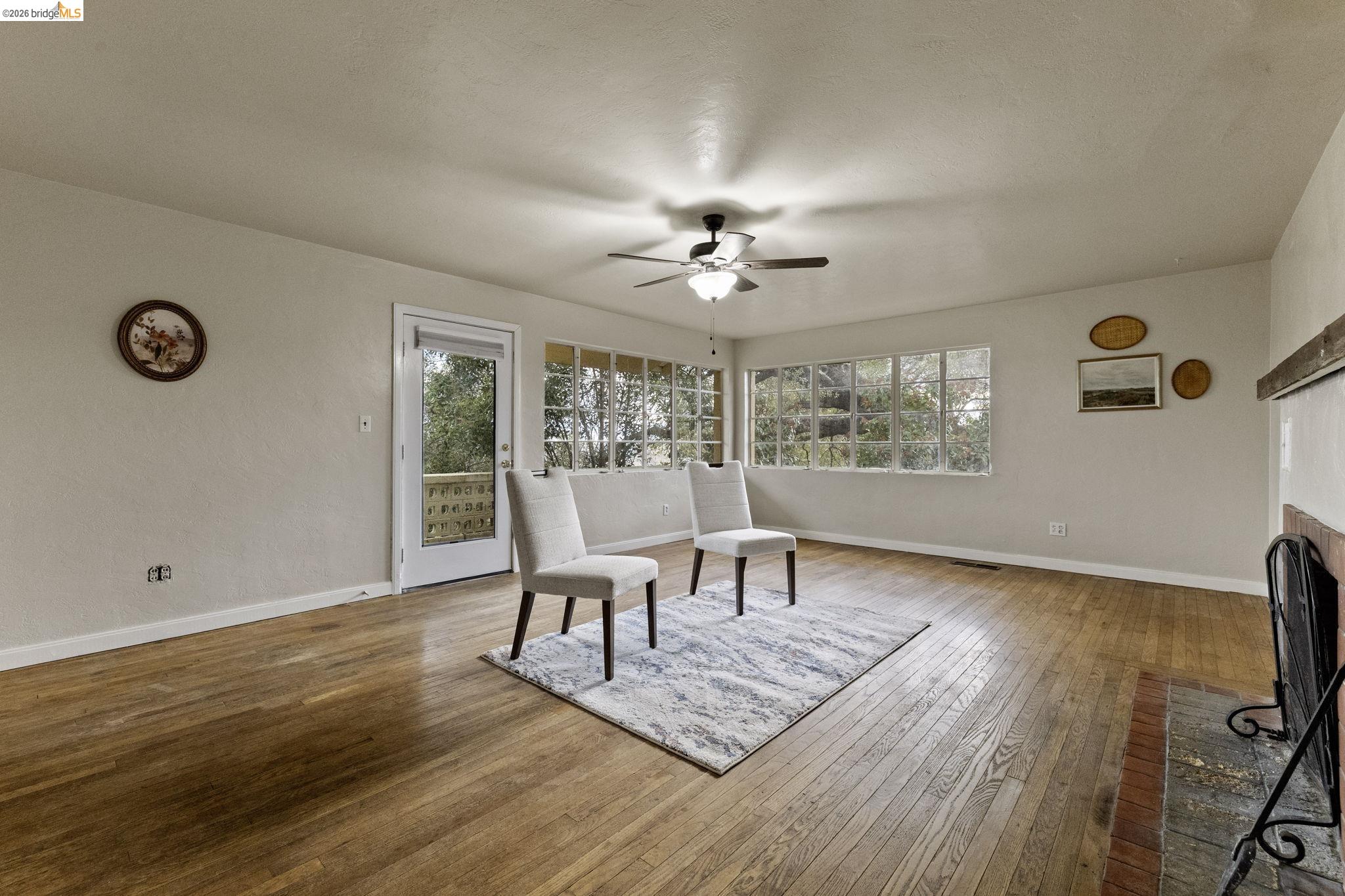 299 Summit Avenue Sonora, CA 95370 - Photo 16 of 38 Living area with wood-type flooring, plenty of natural light, a brick fireplace, and a ceiling fan