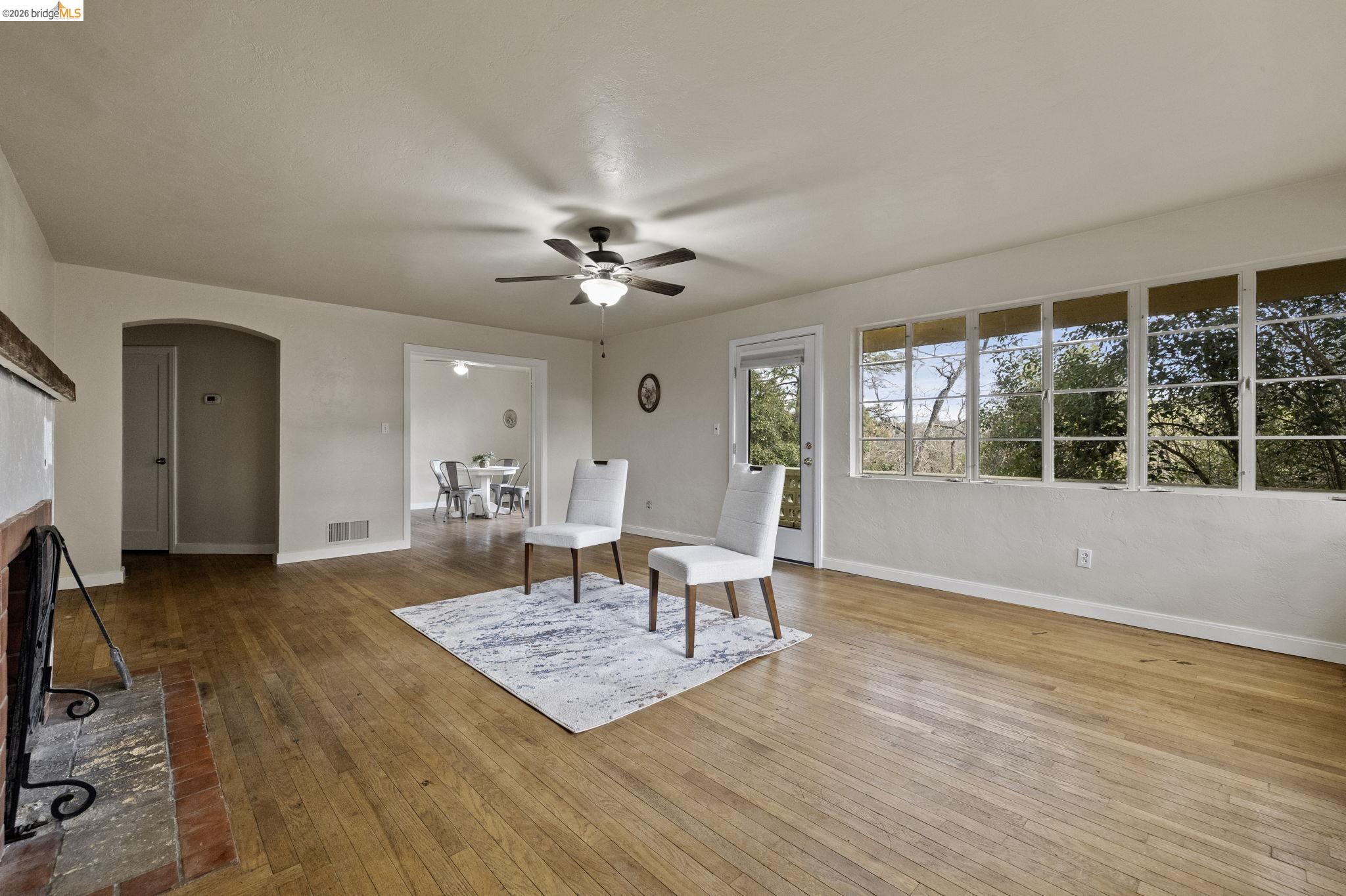 299 Summit Avenue Sonora, CA 95370 - Photo 17 of 38 Living area featuring arched walkways, light wood-style flooring, ceiling fan, and a brick fireplace