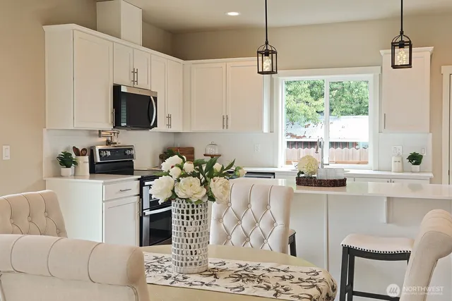 a kitchen with stainless steel appliances kitchen island granite countertop a sink and a white cabinets