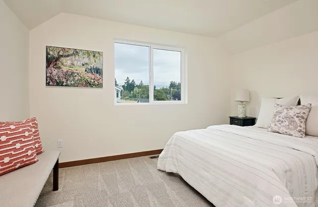 a bedroom with a bed and a painting on the wall
