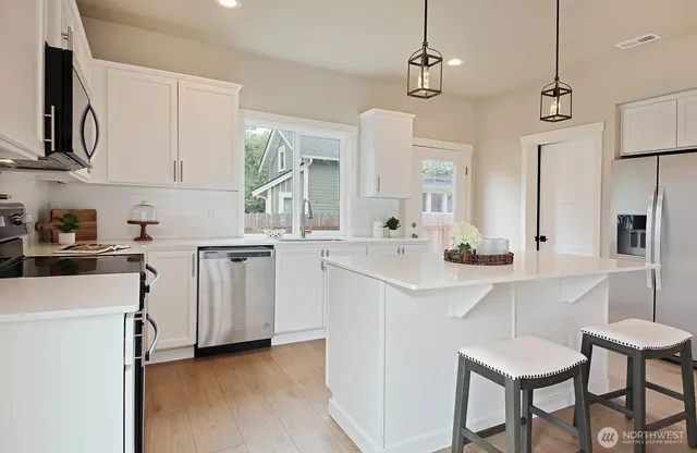 a kitchen with white cabinets and stainless steel appliances