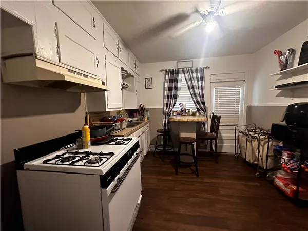 a kitchen with granite countertop a stove and a wooden floors