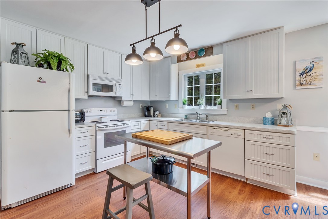 193 Deep Water Lane Reedville, VA 22539 - Photo 8 of 84 a kitchen with stainless steel appliances granite countertop a stove a sink dishwasher a refrigerator and white cabinets with wooden floor