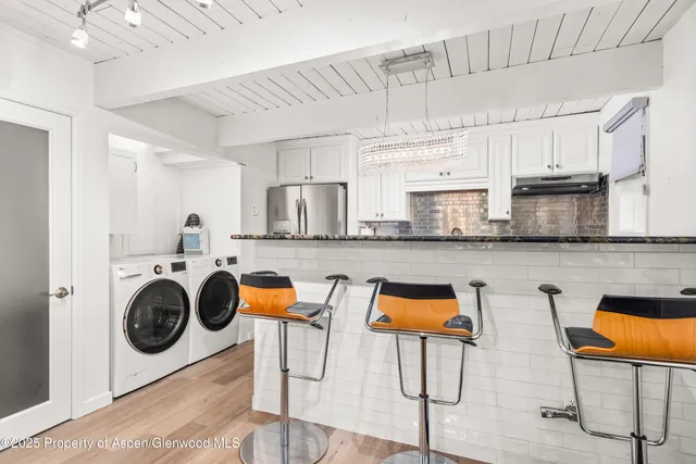 a room with stainless steel appliances kitchen island granite countertop a stove a sink and a refrigerator