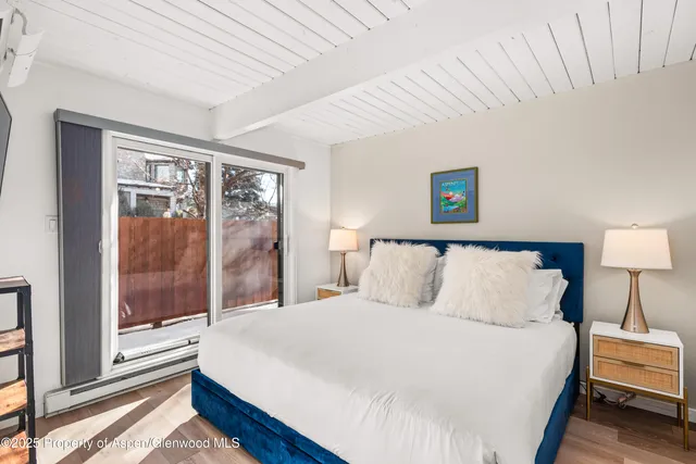 a large bed sitting in a bedroom next to a window