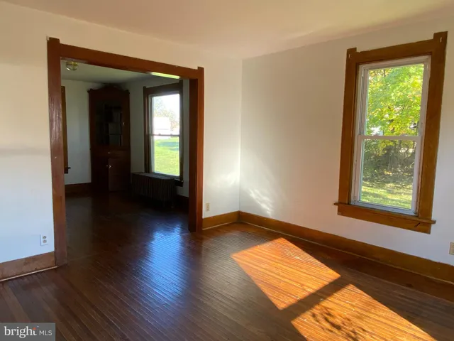 a view of a room with wooden floor and a window