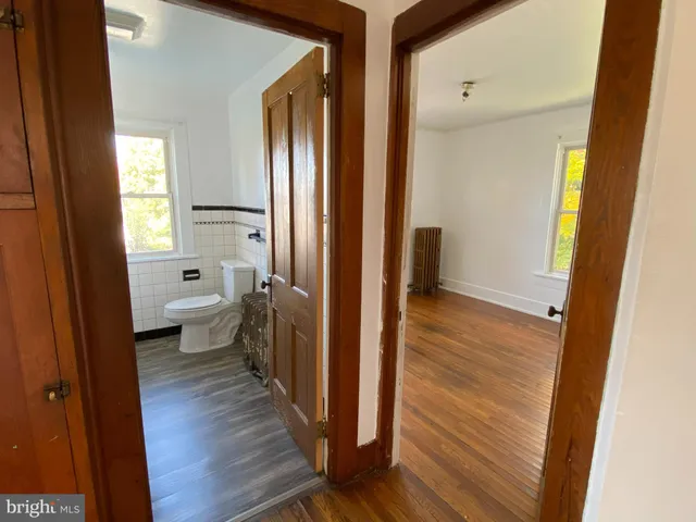 a bathroom with a toilet sink and a wooden floor