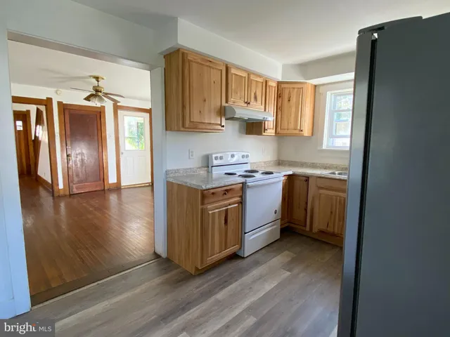 a kitchen with stainless steel appliances white cabinets and wooden floor