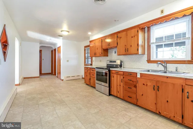 a large kitchen with stainless steel appliances granite countertop a stove a sink and a granite counter tops