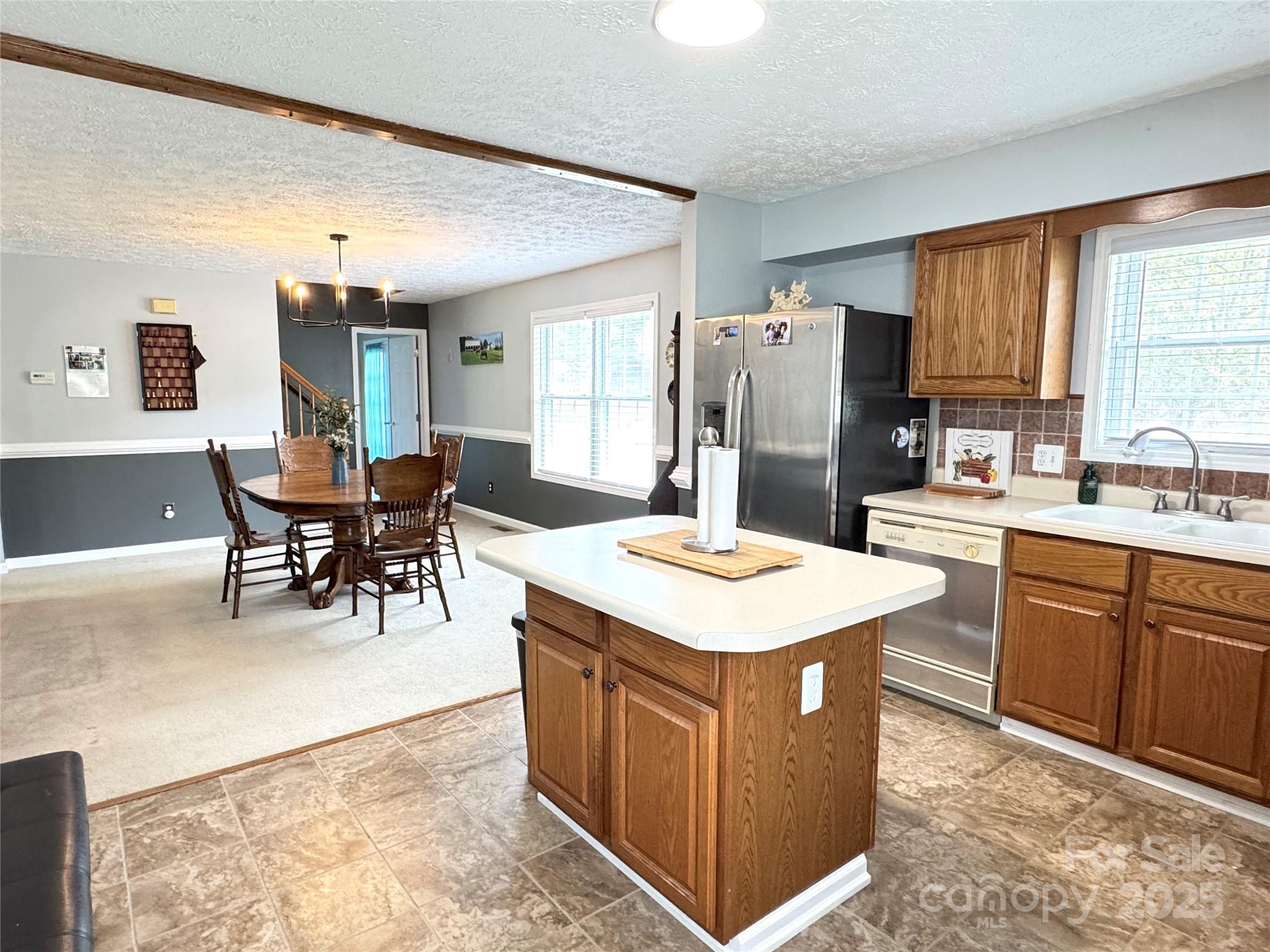 5006 Howell School Road Jonesville, NC 28642 - Photo 24 of 47 a kitchen with a table chairs refrigerator and cabinets