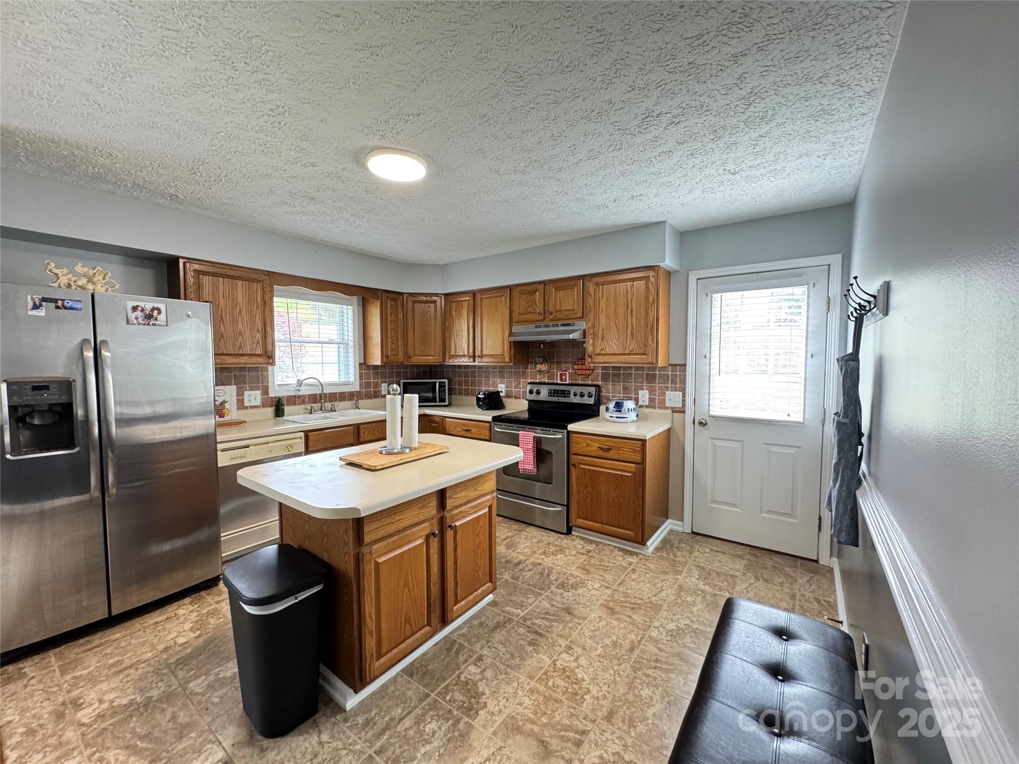 5006 Howell School Road Jonesville, NC 28642 - Photo 25 of 47 a kitchen with a sink refrigerator and cabinets