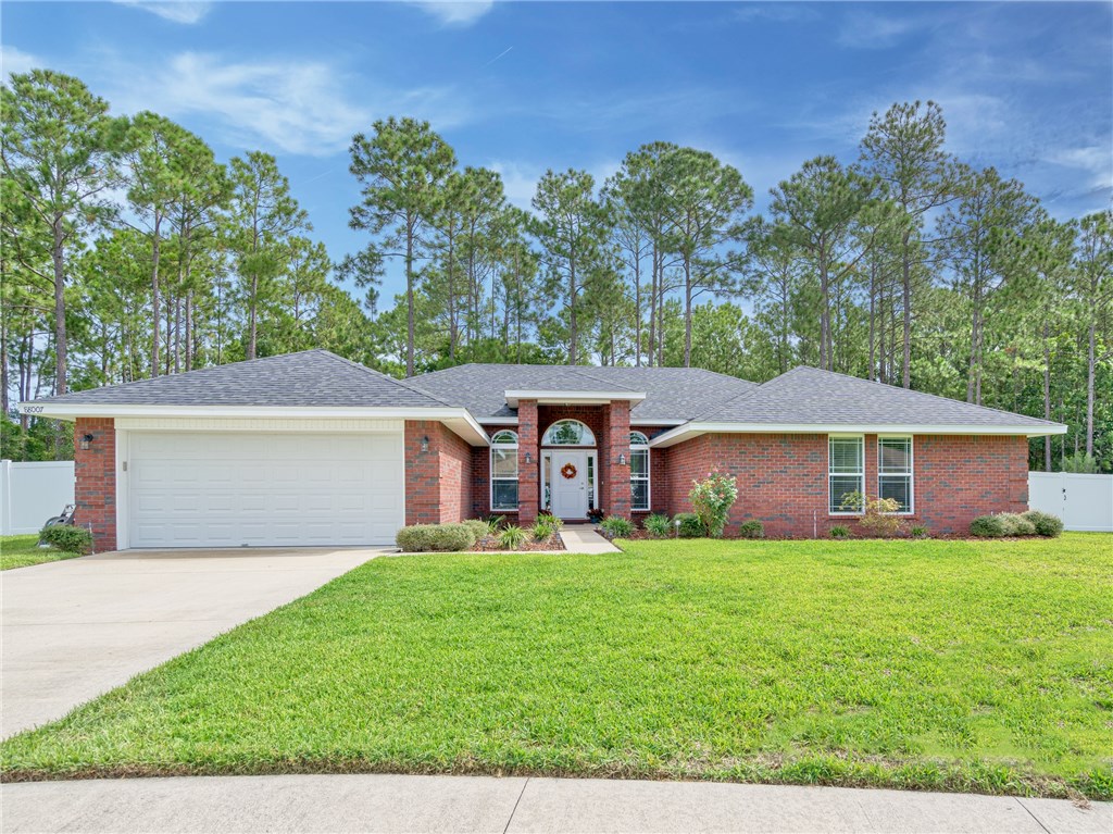 a front view of a house with a yard and trees