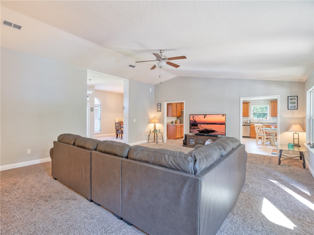 88007 Maybourne Road Yulee, FL 32097 - Photo 13 of 35 a living room with furniture a table and a chandelier