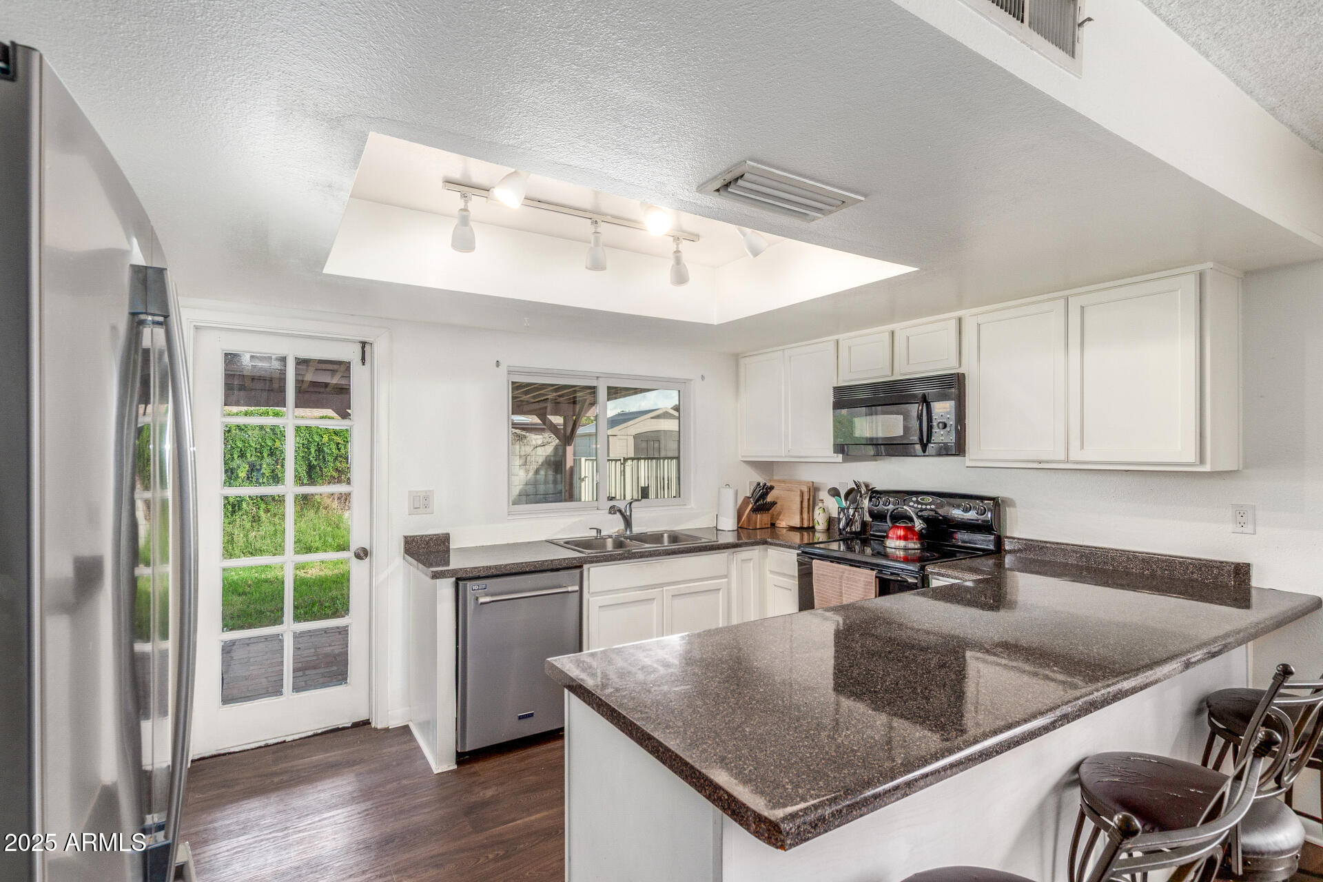 4732 West Davis Road Glendale, AZ 85306 - Photo 11 of 38 a kitchen with stainless steel appliances granite countertop a sink a stove and a refrigerator