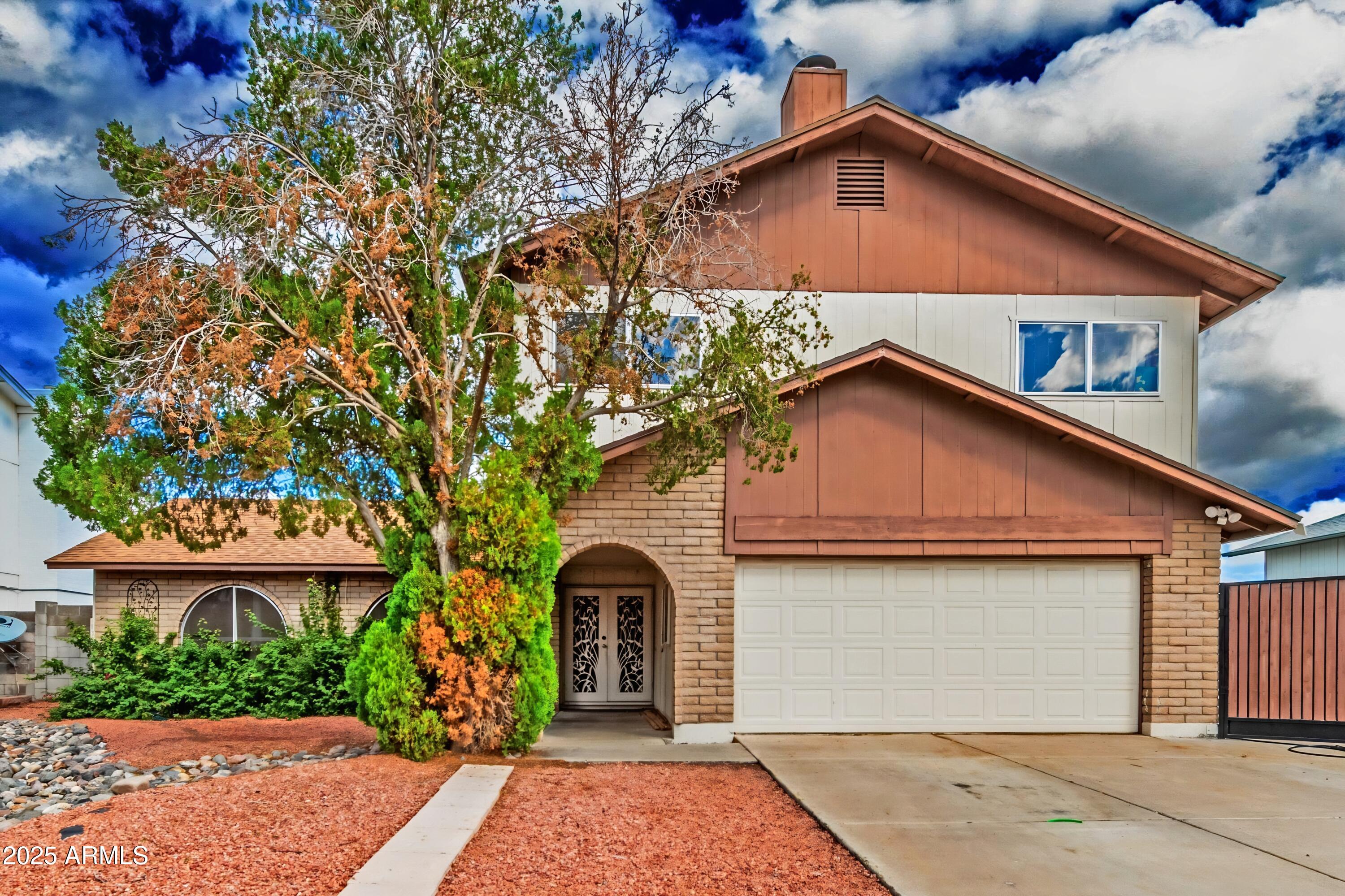 4732 West Davis Road Glendale, AZ 85306 - Photo 2 of 38 a front view of a house with a yard and garage