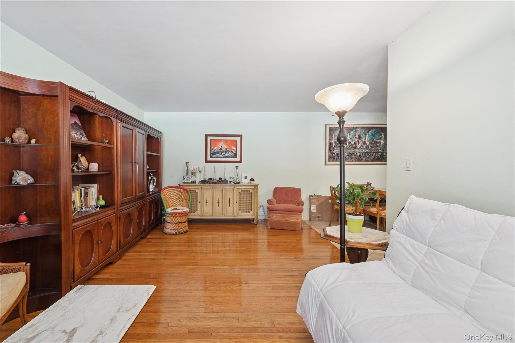 32-40 92nd Street, Unit 107 Queens, NY 11369 - Photo 6 of 16 a living room with furniture and a book shelf
