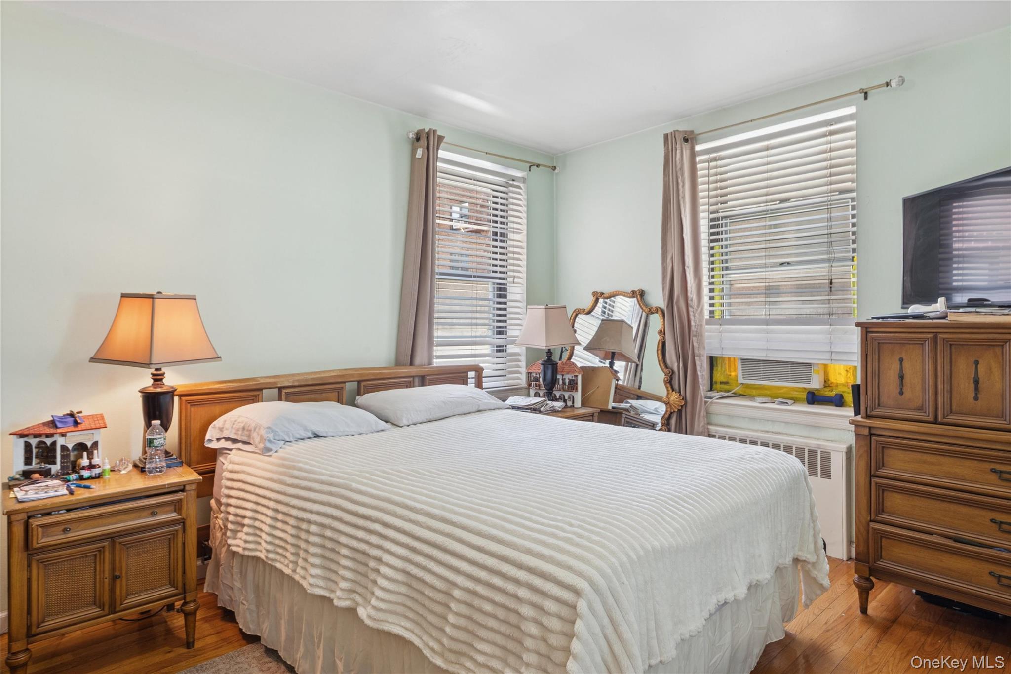 32-40 92nd Street, Unit 107 Queens, NY 11369 - Photo 9 of 16 a bedroom with a bed and flat screen tv