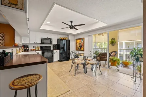 a living room with stainless steel appliances furniture a dining table and a flat screen tv