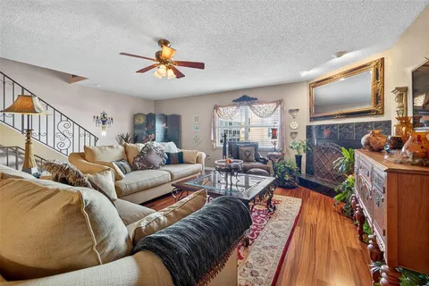a living room with furniture a flat screen tv and a floor to ceiling window