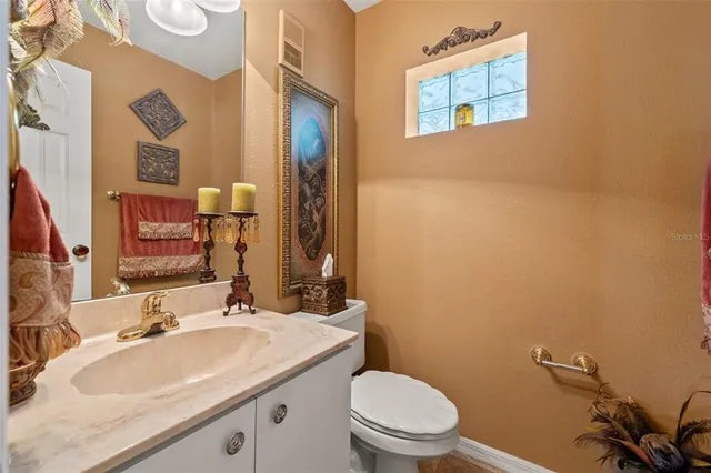 a bathroom with a sink vanity mirror and toilet
