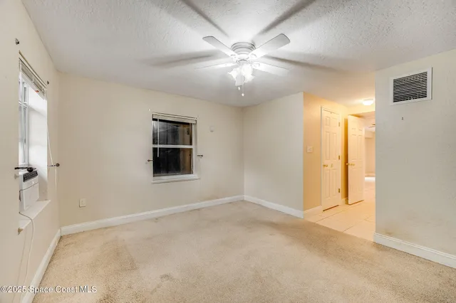 a view of an empty room with a ceiling fan