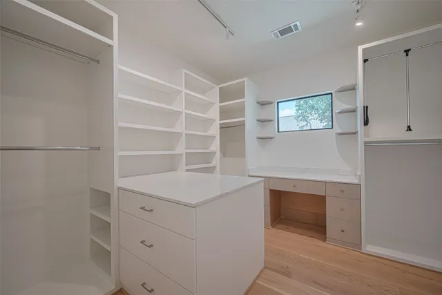 a workspace with white cabinets and a wooden floor