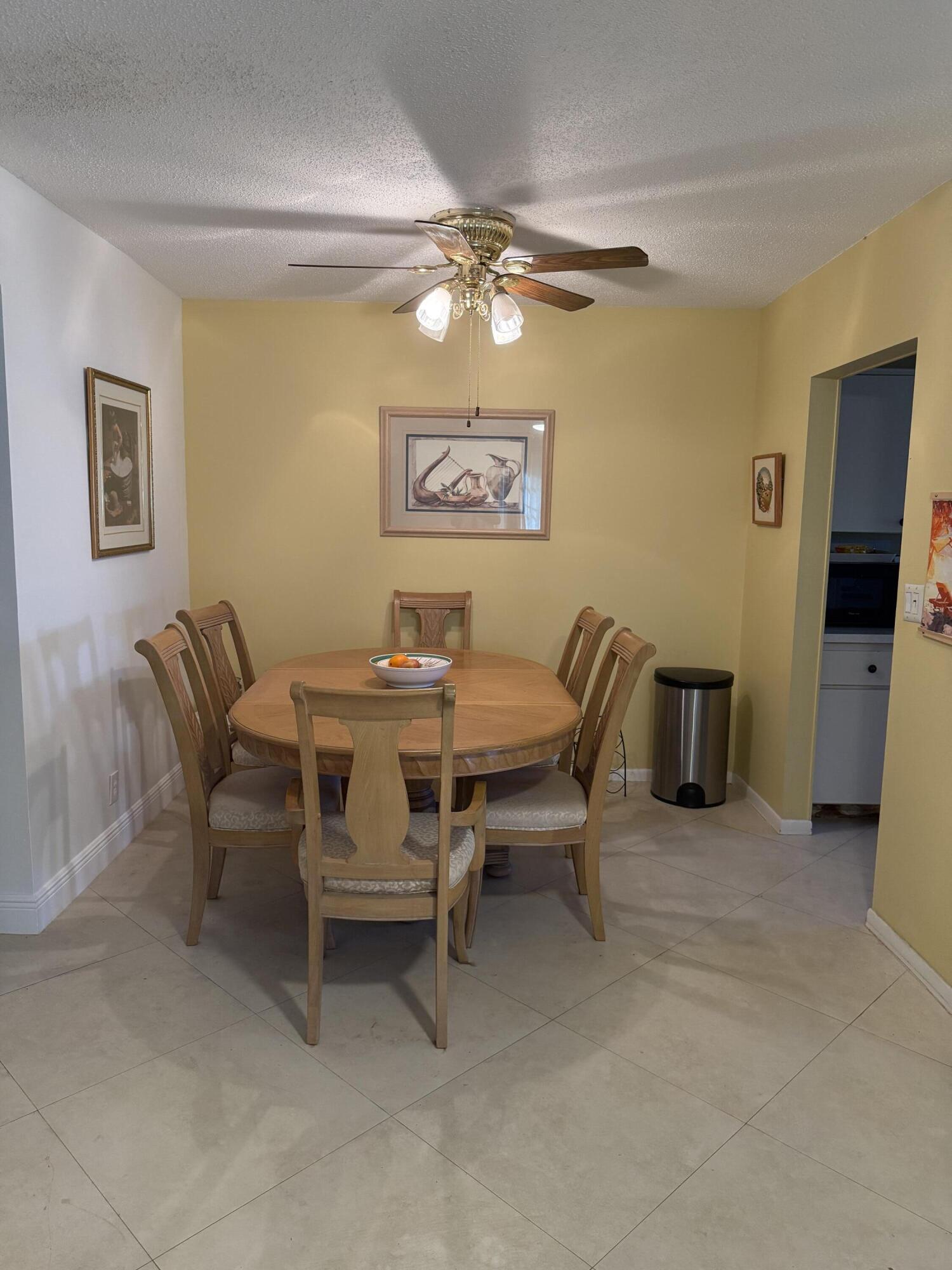 3311 Valley Road, Unit D Boynton Beach, FL 33435 - Photo 12 of 26 a dining room with furniture and a chandelier