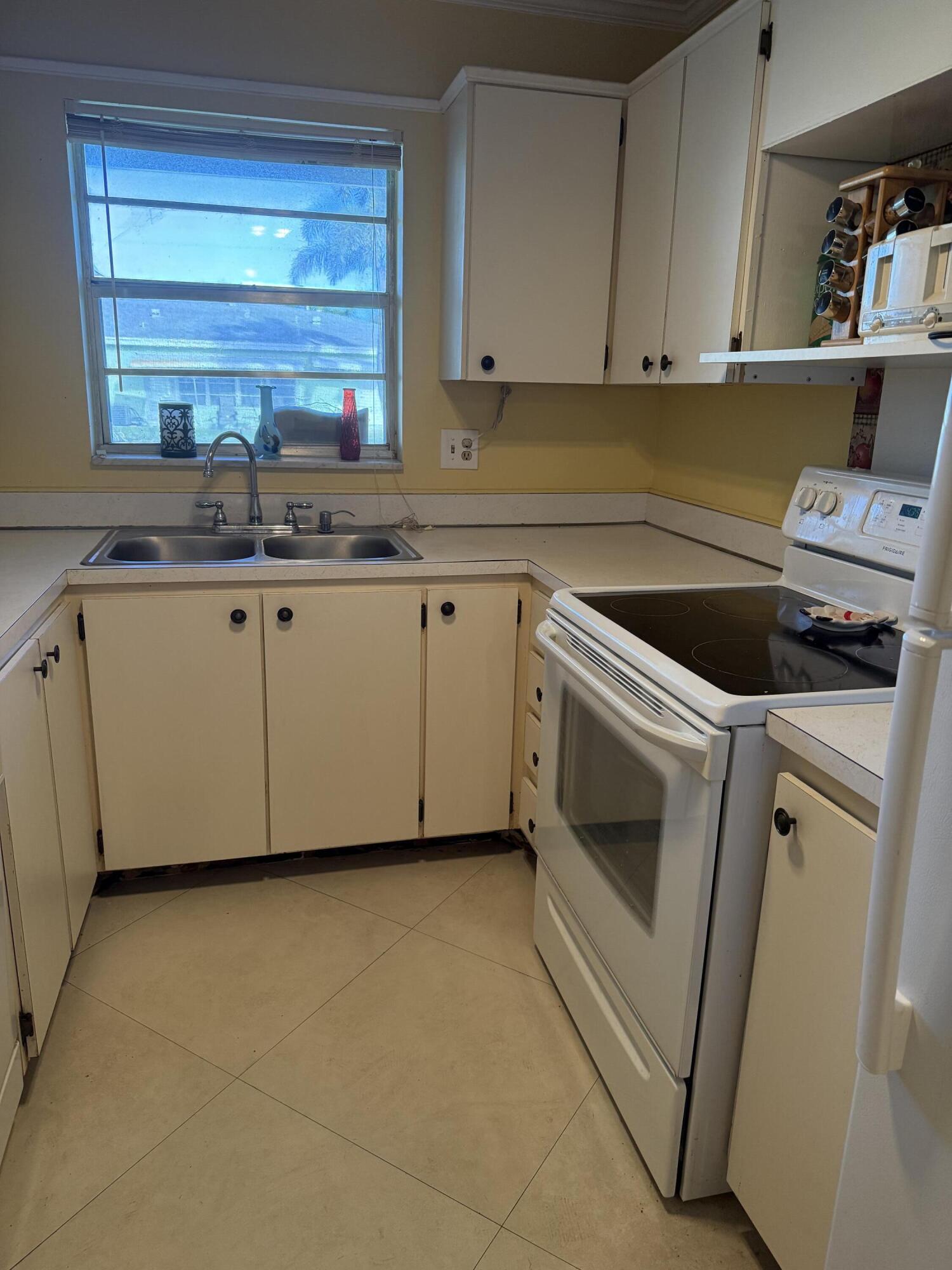 3311 Valley Road, Unit D Boynton Beach, FL 33435 - Photo 13 of 26 a kitchen with granite countertop a sink a stove and cabinets