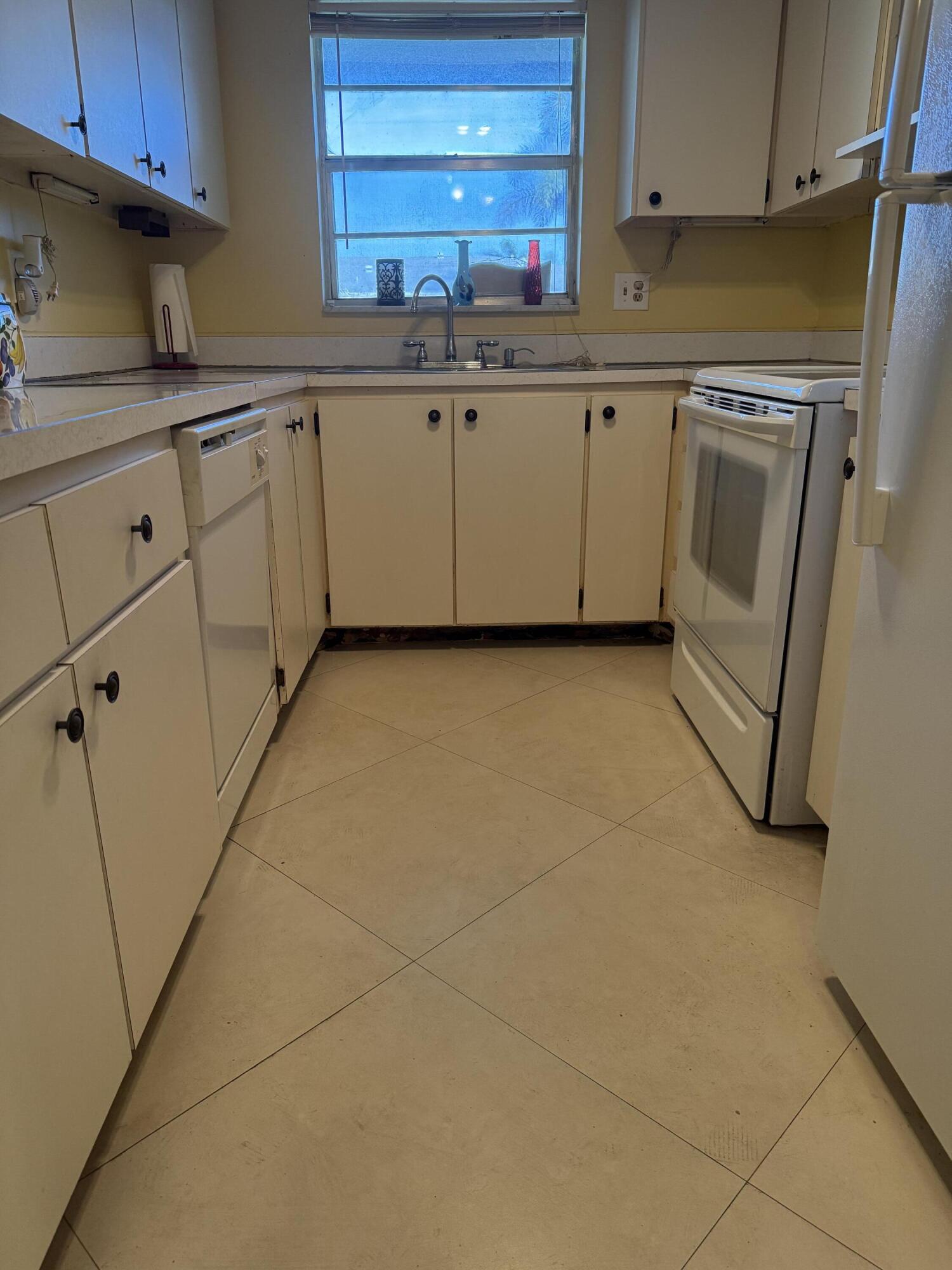 3311 Valley Road, Unit D Boynton Beach, FL 33435 - Photo 14 of 26 a kitchen with granite countertop a sink a stove and cabinets