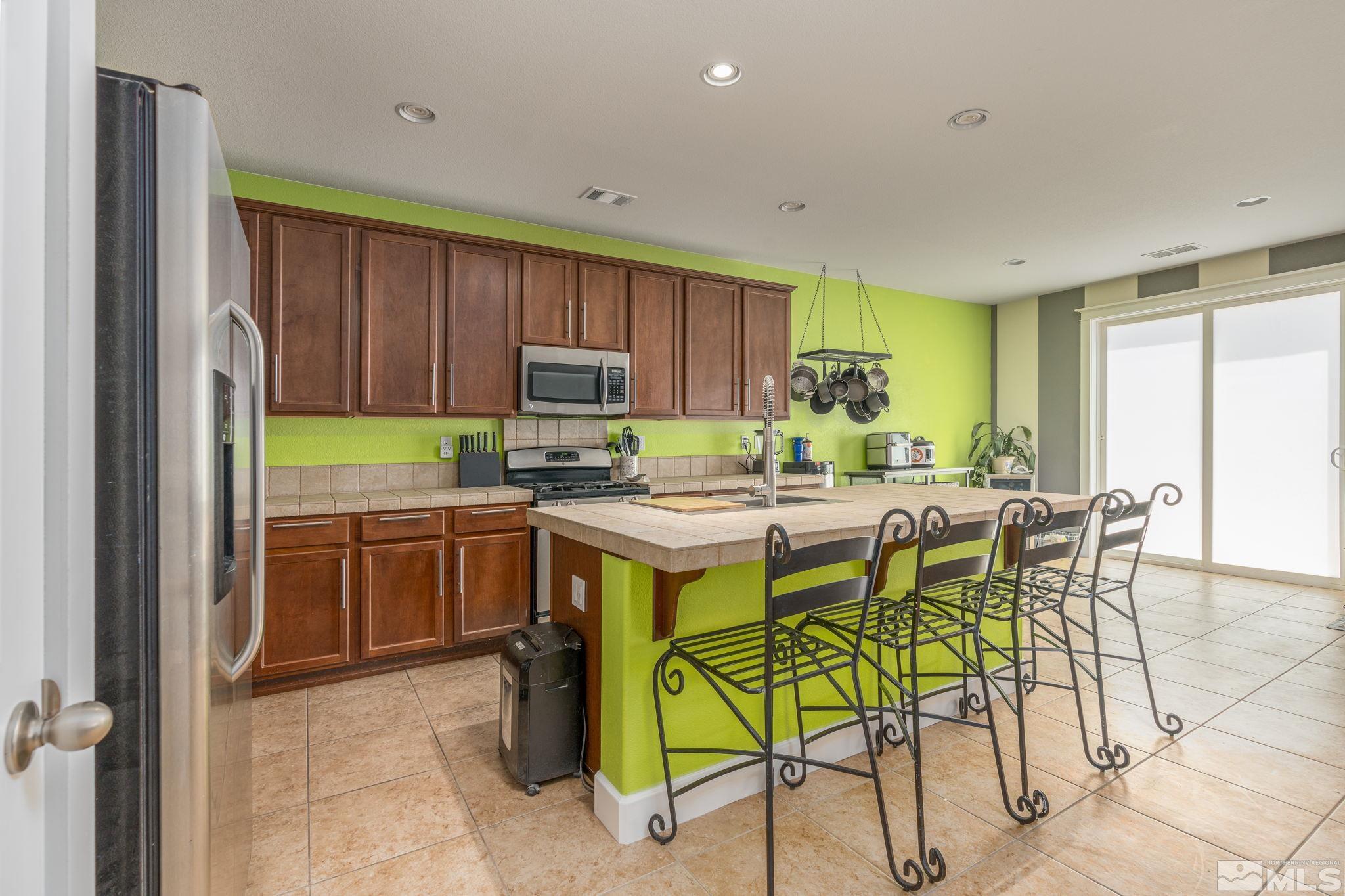 9360 Spotted Horse Road Reno, NV 89521 - Photo 8 of 38 a kitchen with a stove a sink and a refrigerator