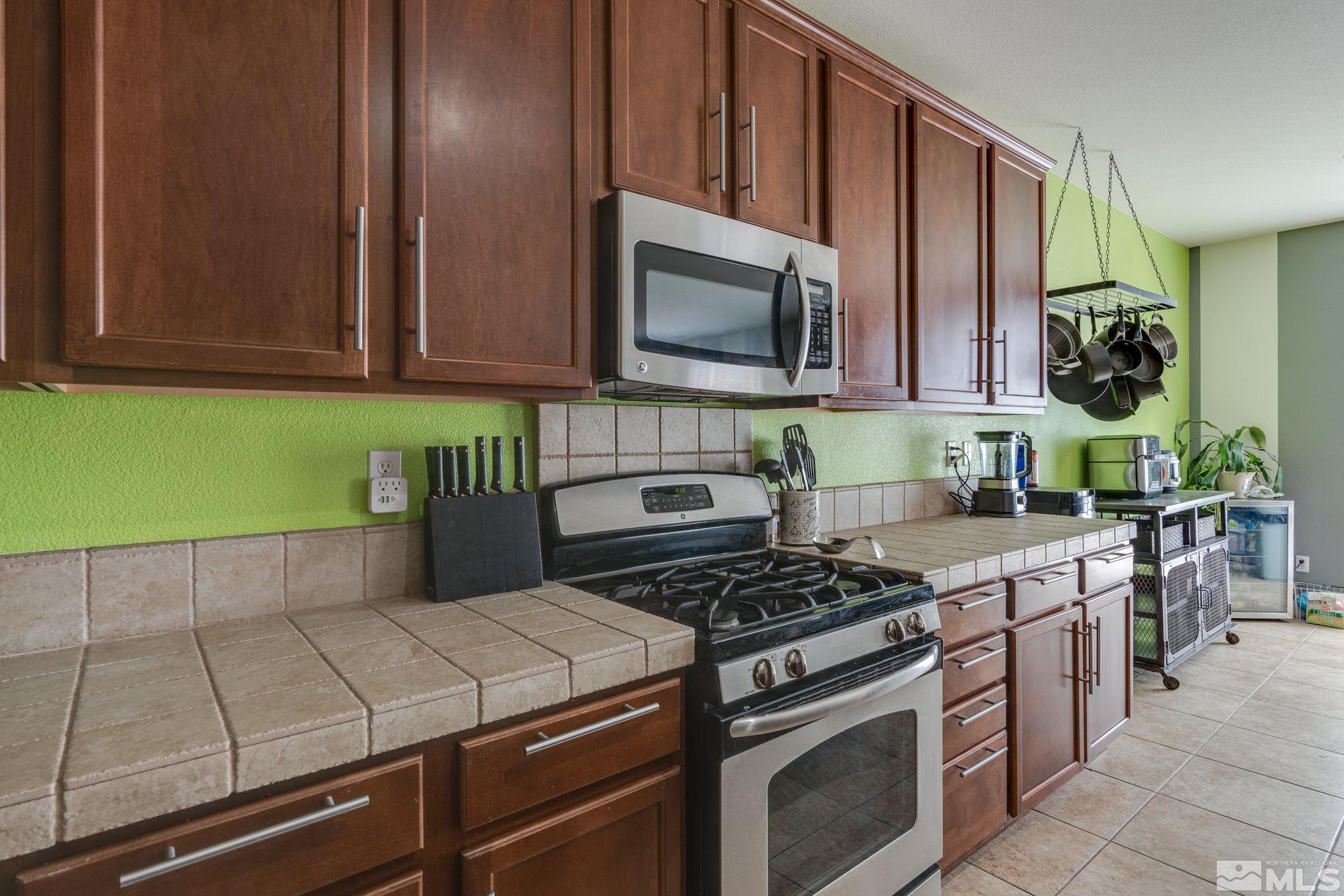 9360 Spotted Horse Road Reno, NV 89521 - Photo 9 of 38 a kitchen with stainless steel appliances granite countertop a stove a sink and a microwave