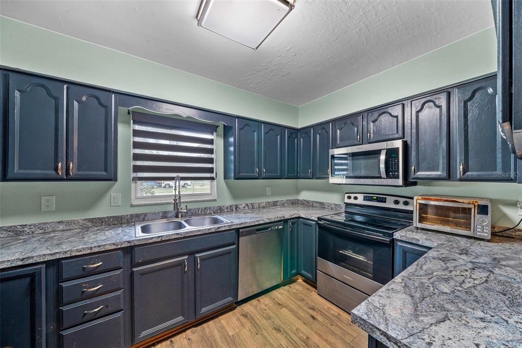 9318 Spring Terrace Ocala, FL 34472 - Photo 5 of 19 a kitchen with stainless steel appliances granite countertop a sink stove and microwave