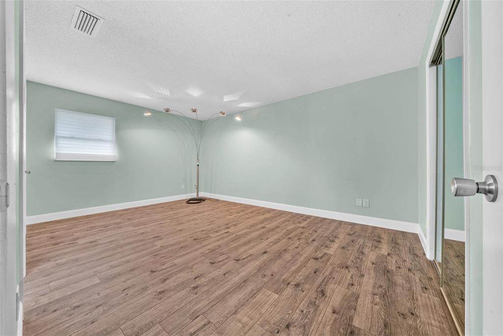 9318 Spring Terrace Ocala, FL 34472 - Photo 6 of 19 an empty room with wooden floor and windows