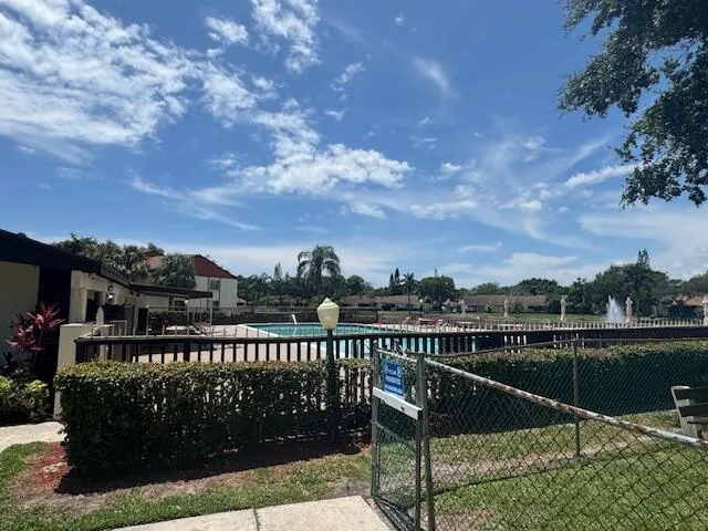 a view of swimming pool with outdoor seating and green space
