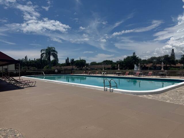 4969 Sable Pine Circle, Unit D1 West Palm Beach, FL 33417 - Photo 23 of 24 a view of swimming pool with outdoor seating and green space