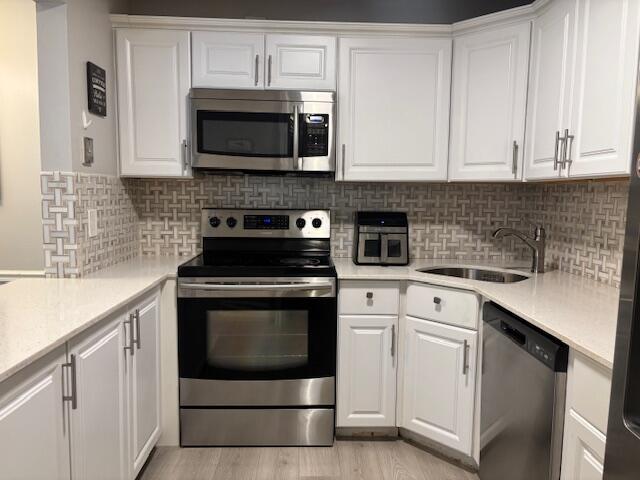 4969 Sable Pine Circle, Unit D1 West Palm Beach, FL 33417 - Photo 4 of 24 a kitchen with stainless steel appliances granite countertop white cabinets a stove a sink and dishwasher