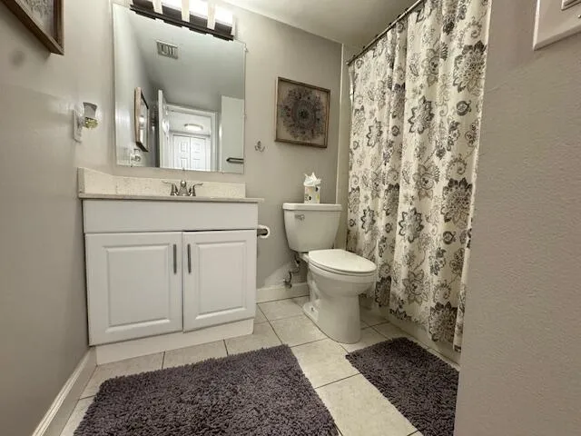 a bathroom with a granite countertop toilet a sink and a mirror