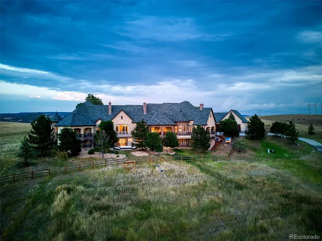 a view of a house with a big yard and large trees