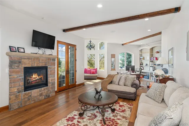 a living room with furniture a flat screen tv and a fireplace
