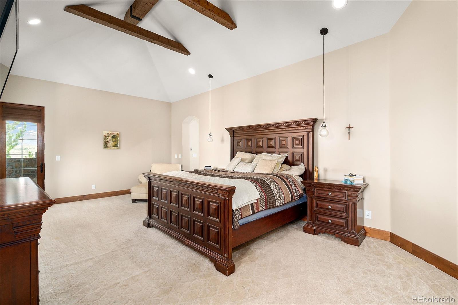 5740 Lambert Ranch Trail Sedalia, CO 80135 - Photo 14 of 48 a bedroom with a bed and a chandelier