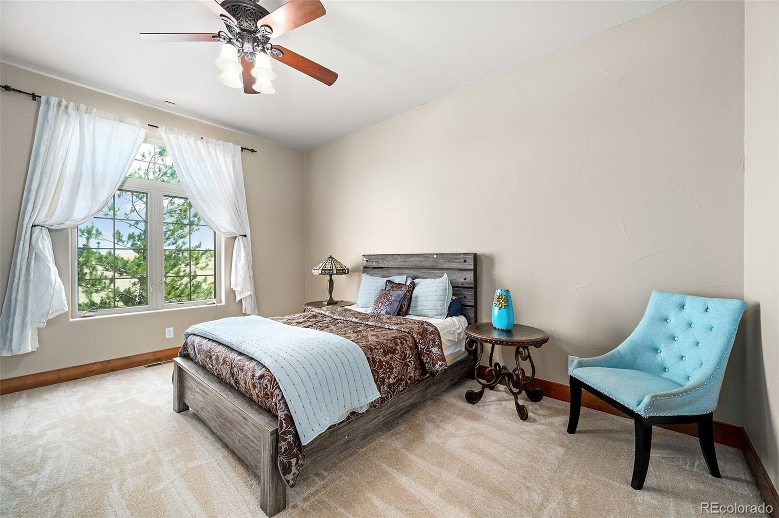 5740 Lambert Ranch Trail Sedalia, CO 80135 - Photo 17 of 48 a bedroom with a bed and a chandelier