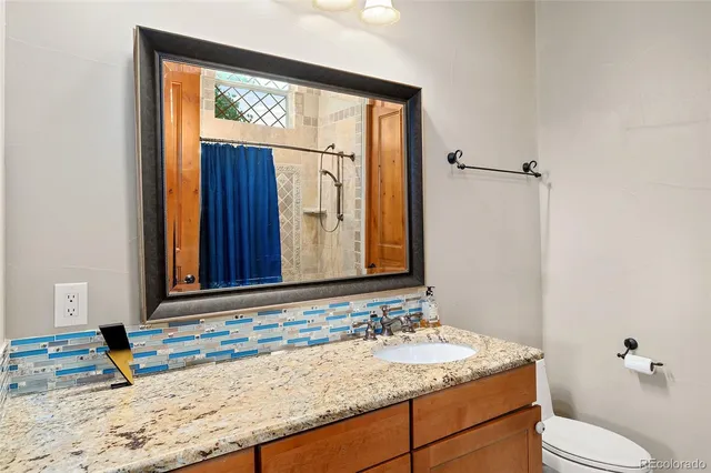 a bathroom with a granite countertop sink and a mirror