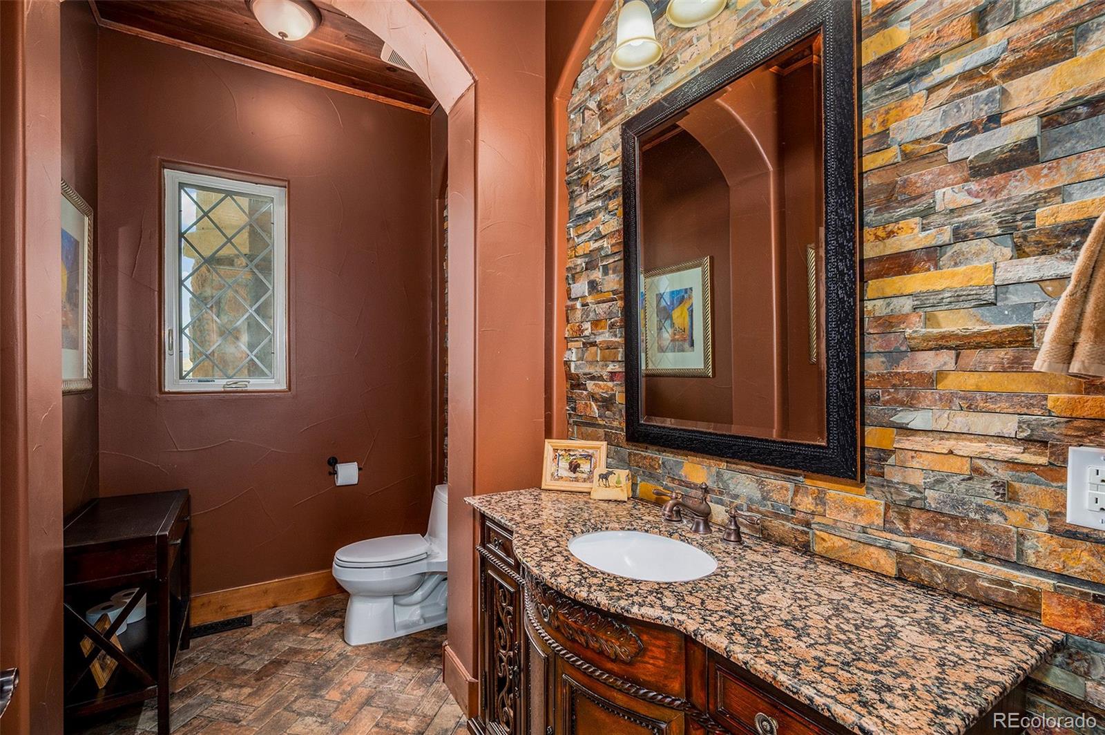 5740 Lambert Ranch Trail Sedalia, CO 80135 - Photo 21 of 48 a bathroom with a granite countertop toilet sink and mirror