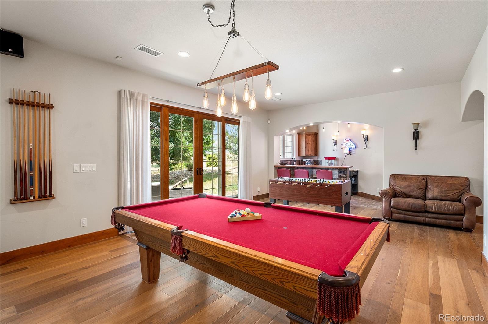5740 Lambert Ranch Trail Sedalia, CO 80135 - Photo 25 of 48 a room with gym equipment pool table furniture and windows