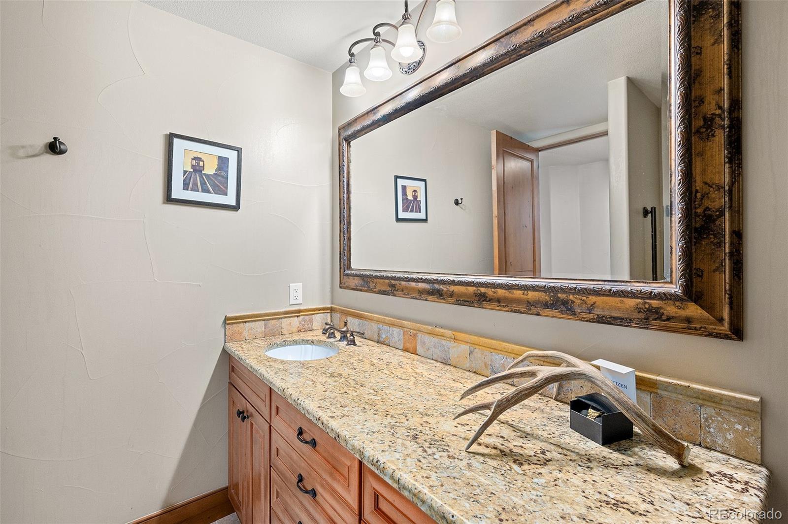 5740 Lambert Ranch Trail Sedalia, CO 80135 - Photo 33 of 48 a bathroom with a granite countertop sink and a mirror