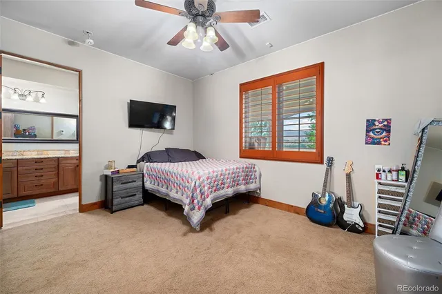 a bedroom with a bed a couch and a flat screen tv