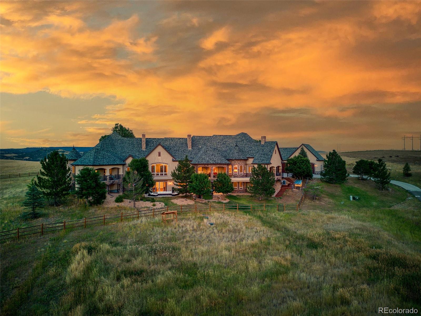 5740 Lambert Ranch Trail Sedalia, CO 80135 - Photo 40 of 48 a view of a big house with a big yard and palm trees