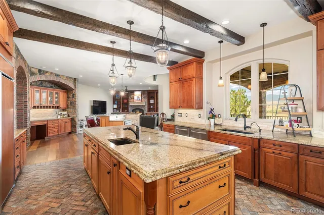 a kitchen with stainless steel appliances granite countertop a sink a counter space and a view of living room